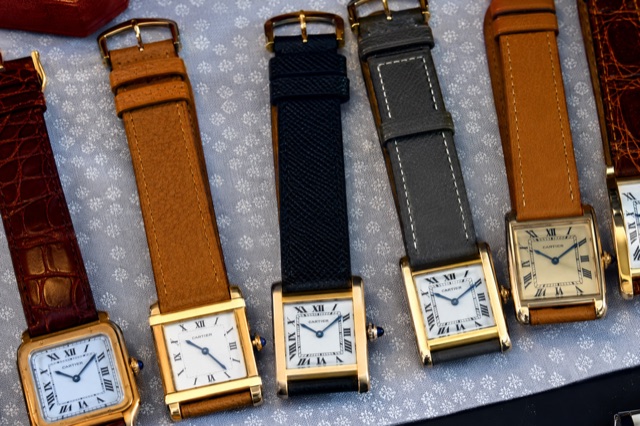 A row of vintage Cartier tank watches on leather straps