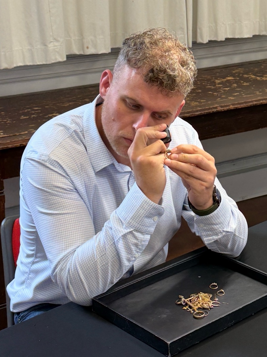 Dan examining a ring through a jeweller&rsquo;s loupe at the valuation table